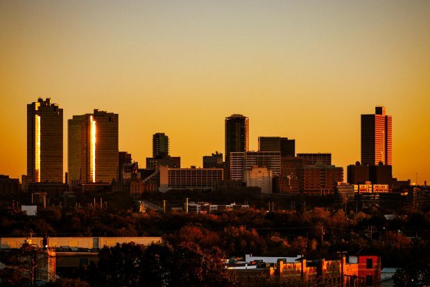 Dramatic sunset view of Fort Worth, Texas skyline. Warm tones highlight the city's architecture.